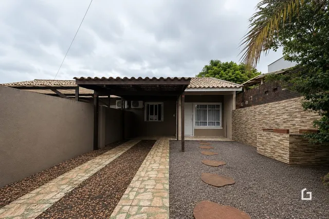 Vista externa da fachada de uma residência em Lajeado, Brasil com área de passagem coberta.