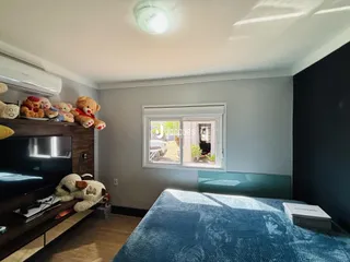Quarto com cama e televisão em ambiente interno.