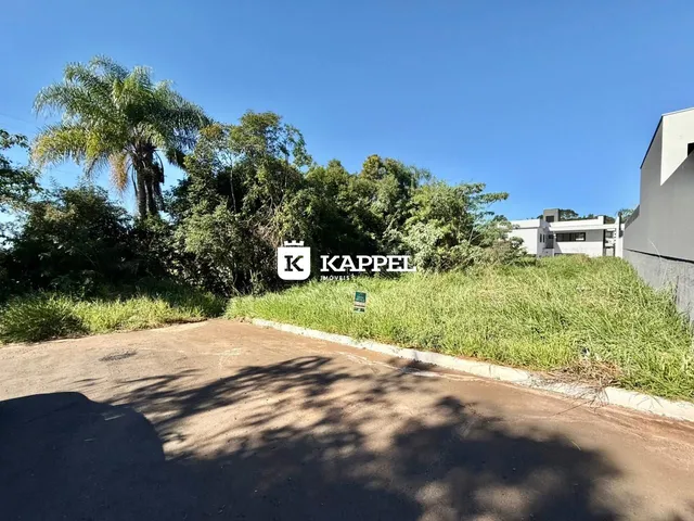 Vista externa da propriedade mostrando uma área de grama e uma estrada de terra sob um céu azul.