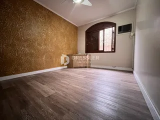 Sala de estar com parede texturizada e piso de madeira em um imóvel no Brasil.