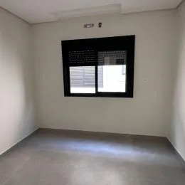 Foto de um ambiente interno com paredes brancas e piso cinza.