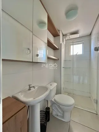 Foto interna de um banheiro moderno com box de vidro.