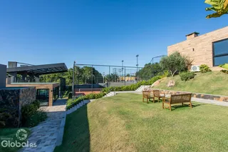 Vista externa de uma propriedade com jardim e área de lazer.