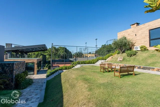 Vista externa de uma propriedade com jardim e área de lazer.