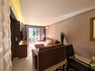 Sala de estar com sofá marrom e piso de madeira clara.
