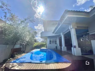 Foto de uma piscina externa com deck de madeira em uma residência.