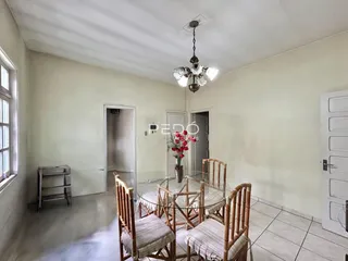 Uma sala de jantar clara com mesa e cadeiras de madeira.
