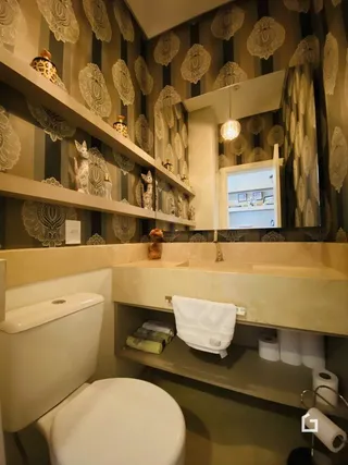 Foto de uma parede com papel de parede e um vaso sanitário em um imóvel.