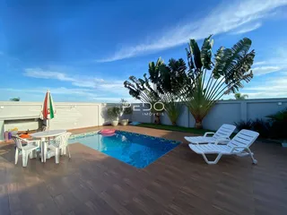 Vista da piscina e área externa com palmeiras e esplanadas.