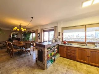 Sala com piso de madeira e móveis de cozinha integrada.