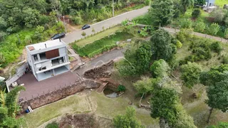 Vista aérea de uma propriedade residencial com área verde e vegetação.