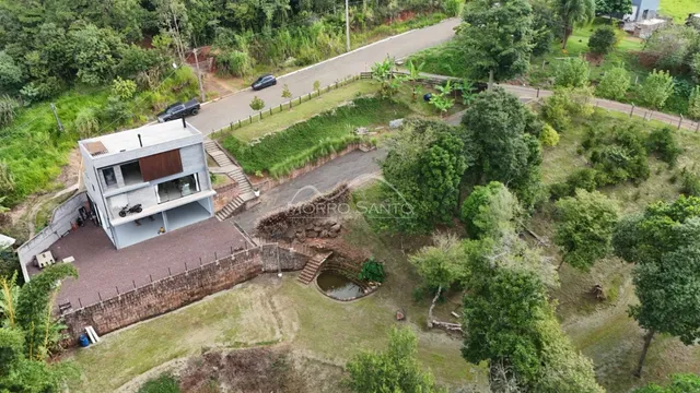Vista aérea de uma propriedade residencial com área verde e vegetação.