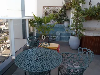Vista externa de uma área com mobiliário de ferro forjado e plantas em Lajeado.