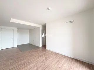 Ambiente interno amplo com piso de madeira clara.