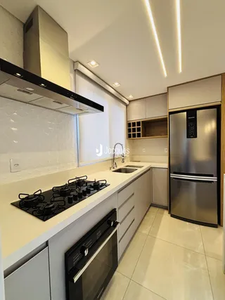 Uma cozinha moderna com armários brancos e bancadas claras.