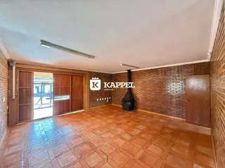 Ambiente interno com piso de ladrilho terracota e paredes de tijolo aparente.
