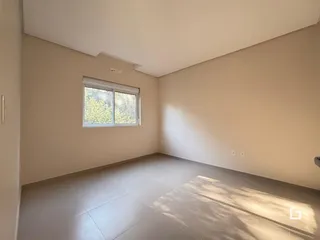 Foto de um cômodo interno com paredes claras e piso de cerâmica.