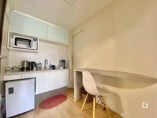 Foto de uma cozinha com armários brancos e piso de madeira clara.