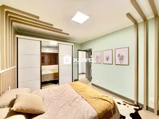 Quarto com cama e armário em um ambiente com paredes verde-claro.