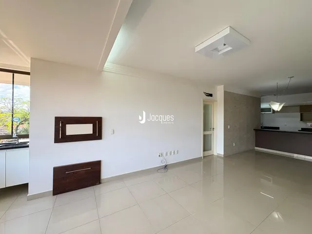 A sala de estar apresenta um piso de cerâmica claro e paredes brancas.