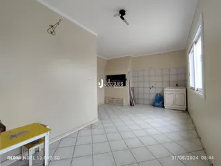 Interior de uma sala com piso de cerâmica e parede clara.