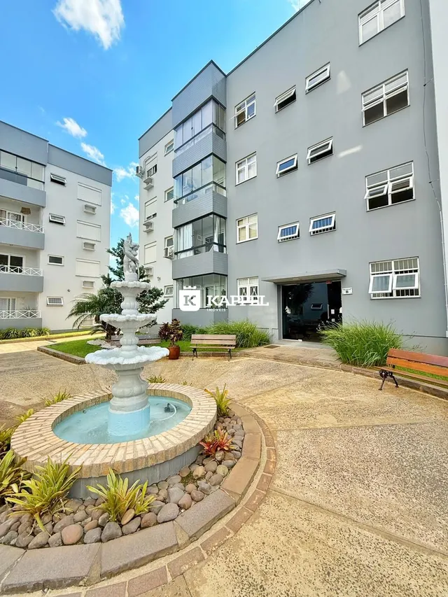 Vista externa de um edifício residencial com uma fonte no jardim.
