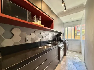 Cozinha moderna com armários e revestimento hexagonal cinza.