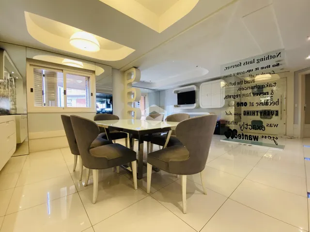Sala de jantar com mesa e cadeiras em um ambiente claro.