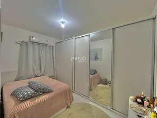 Quarto com cama e portas de vidro no interior de uma residência.