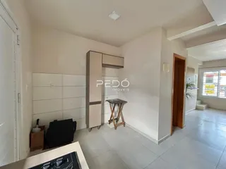Interior de um ambiente claro com armários e piso de cerâmica.