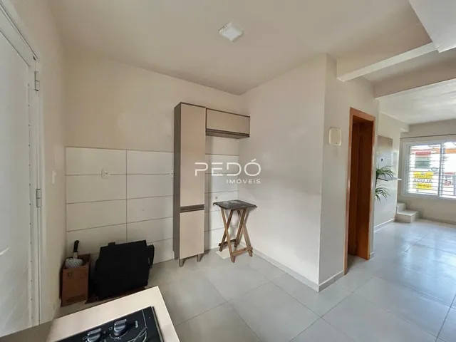 Interior de um ambiente claro com armários e piso de cerâmica.