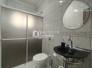 Foto de um banheiro com revestimento de azulejos brancos.