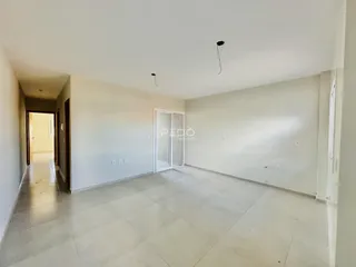 Hall de entrada com piso claro e paredes brancas.