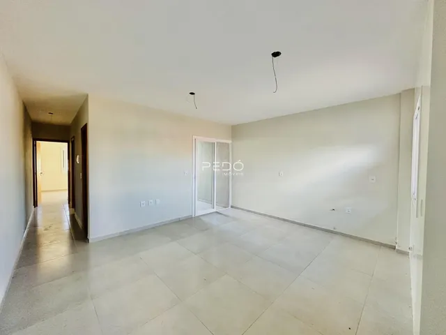 Hall de entrada com piso claro e paredes brancas.