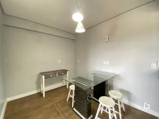 Foto de uma sala com mesa de jantar e bancos em um imóvel.