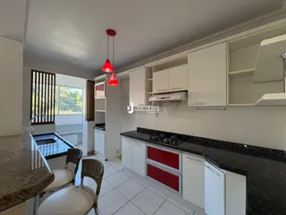 Foto da cozinha de um imóvel em Lajeado, Brasil, mostrando armários brancos e bancadas escuras.