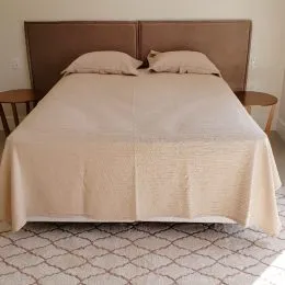 Foto de uma cama com roupa de cama em um quarto.
