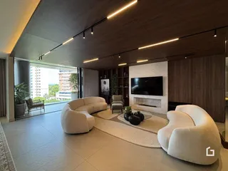 Sala de estar moderna com grandes sofás brancos e piso claro.