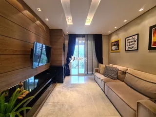 Sala de estar com sofá e televisão em um apartamento.