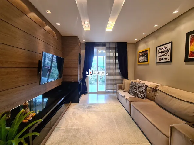 Sala de estar com sofá e televisão em um apartamento.