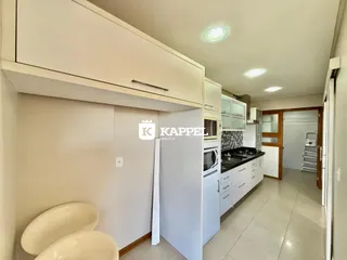 Esta é uma cozinha com armários brancos e piso claro.