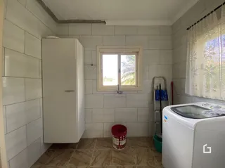 Interior de um corredor com paredes brancas e piso de cerâmica.