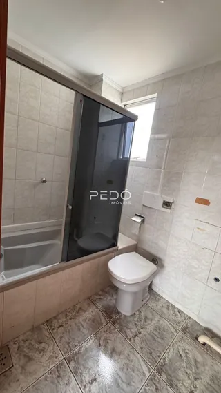 Banheiro com box de vidro e vaso sanitário.