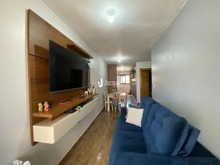 Sala de estar com sofá azul e painel de madeira na residência.