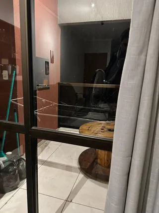 Vista de um corredor interno com paredes em tom salmão e piso de cerâmica.