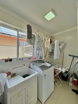 Foto de um ambiente interno com pia e máquina de lavar roupa.