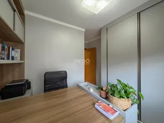 Interior de uma sala com móveis de madeira e paredes cinzas.