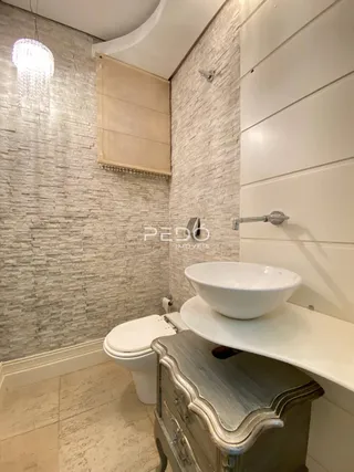 Foto de um banheiro com revestimento de cerâmica e louças sanitárias.