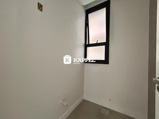 Hall de entrada com uma janela escura na parede.