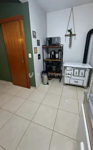 Interior de uma sala com piso de cerâmica e porta de madeira.